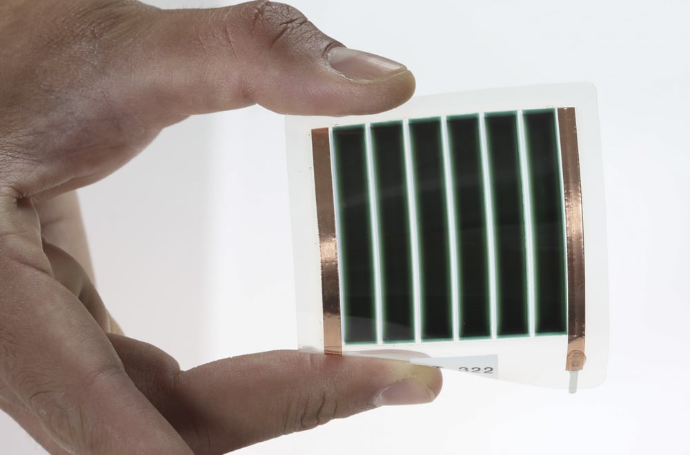 Eine Hand hält ein kleines und biegbares Solarmodul von Dracula Technologies zwischen zwei Fingern
