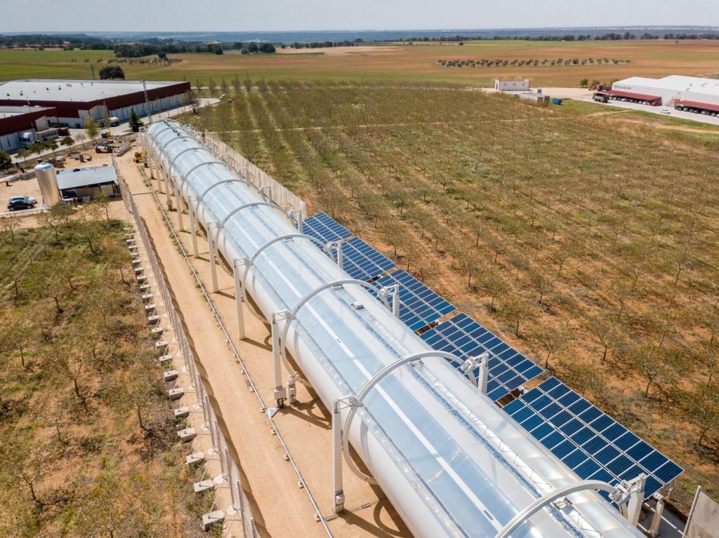 HELIOVIS Anlage in Spanien. Man sieht eine große Kunststoffröhre in einer landwirtschaftlichen Umgebung. 